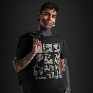 A man with face tattoos and gray face paint wears a black graphic t-shirt featuring a white grid pattern of floral illustrations. He is posed against a dark studio background.