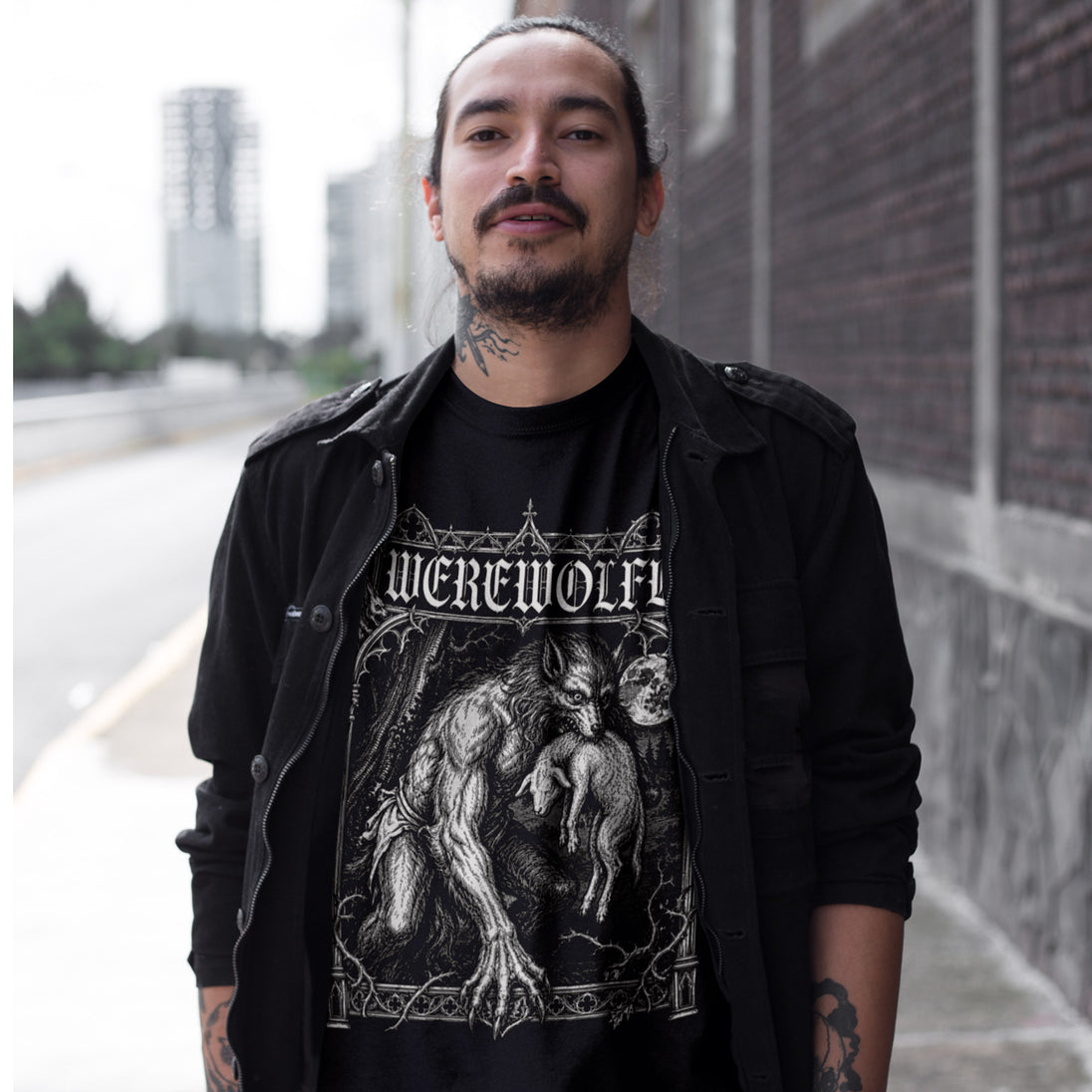Man wearing a black t-shirt with 'Werewolf' design outdoors.