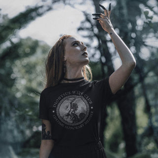 Woman wearing a black leather jacket with a Dionysus Wine Club t-shirt in a forest.