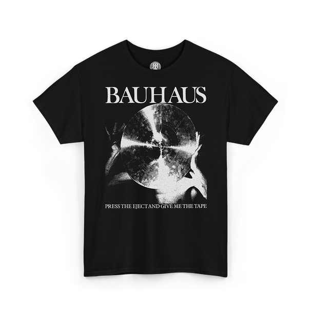 A black short-sleeve t-shirt with a white graphic print of the Bauhaus logo, a circular abstract design, and the text 'PRESS THE EJECT AND GIVE ME THE TAPE' on a white background.