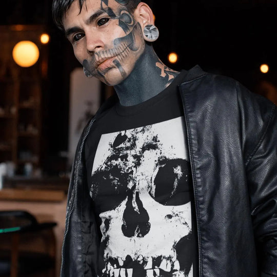 Person wearing a black leather jacket and a black t-shirt with a white skull design in an indoor setting.