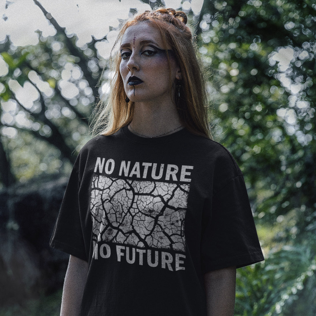 Person wearing a black t-shirt with 'No Nature No Future' text in an outdoor setting