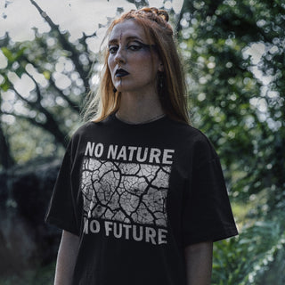 Person wearing a black t-shirt with 'No Nature No Future' text in an outdoor setting