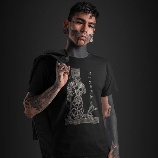 Tattooed man wearing a blackGod Marduk T-Shirt with a graphic design on a dark background