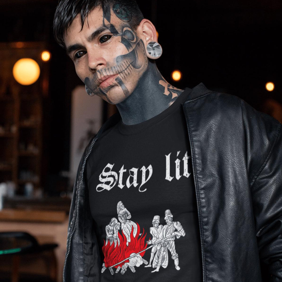 Man wearing a black t-shirt with 'Stay Lit' design in a forest setting