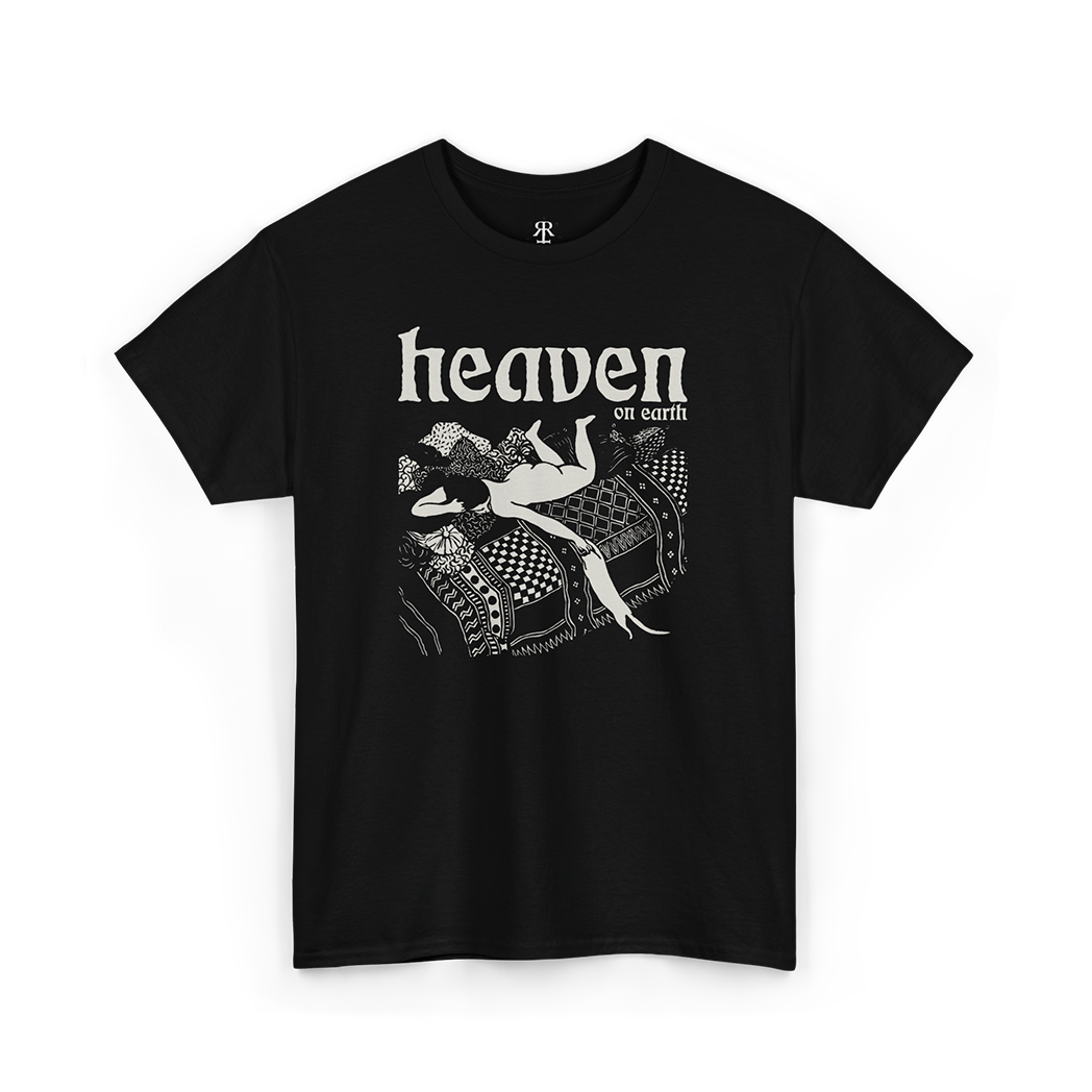 Black T-shirt with a graphic print of a woman playing with a cat in bed with 'HEAVEN ON EARTH' text above it.