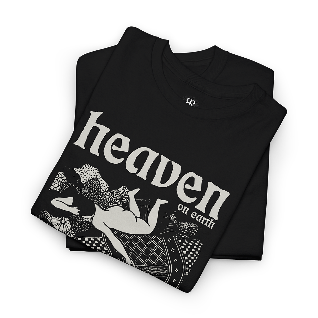 Black T-shirt with a graphic print of a woman playing with a cat in bed with 'HEAVEN ON EARTH' text above it.