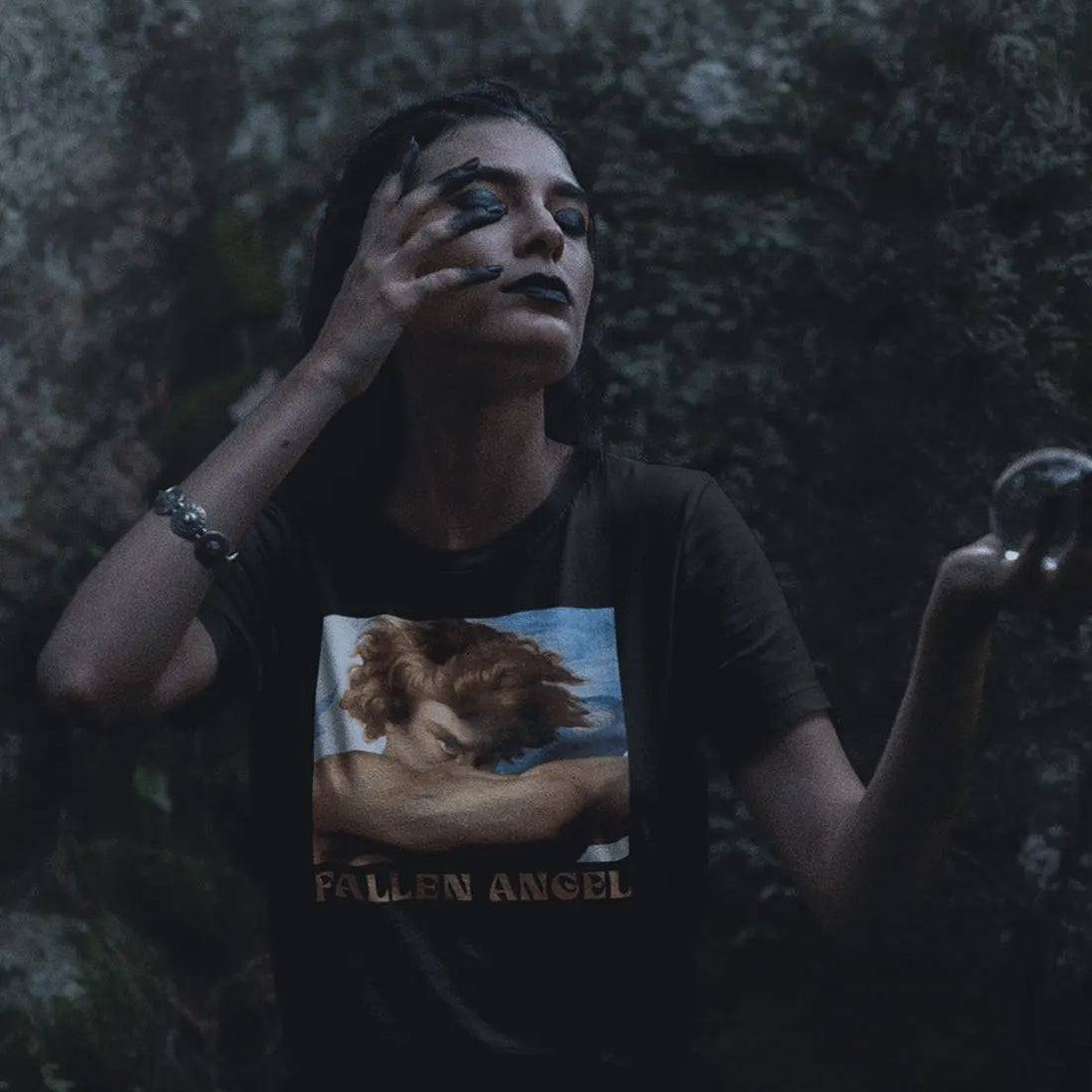 Person wearing a t-shirt with 'Fallen Angel' design against a dark background