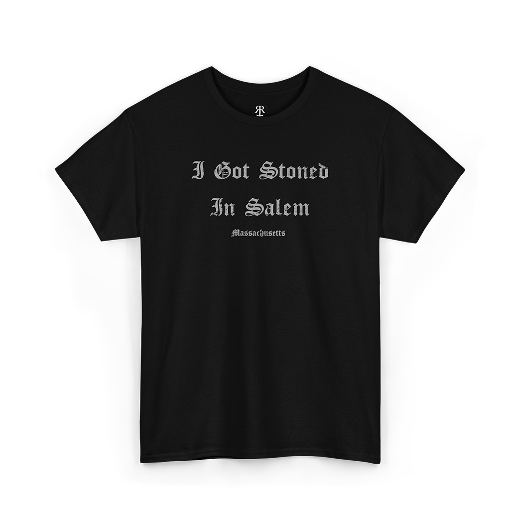 A black T-shirt with the text 'I GOT STONED IN SALEM' printed in white capital letters.