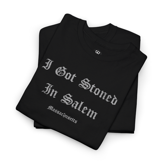 A black T-shirt with the text 'I GOT STONED IN SALEM' printed in white capital letters.