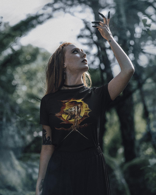 Woman wearing a black The Ancient Of Days T-Shirt, standing in a forest.