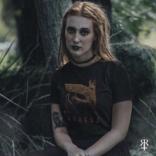 Person wearing a black t-shirt with lamassu winged lion design in a forest setting