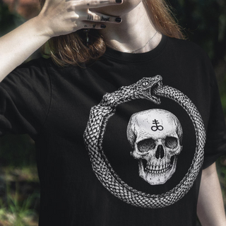 Woman wearing Black crew neck t-shirt with a graphic of a skull in the center, surrounded by a ouroboros symbol.