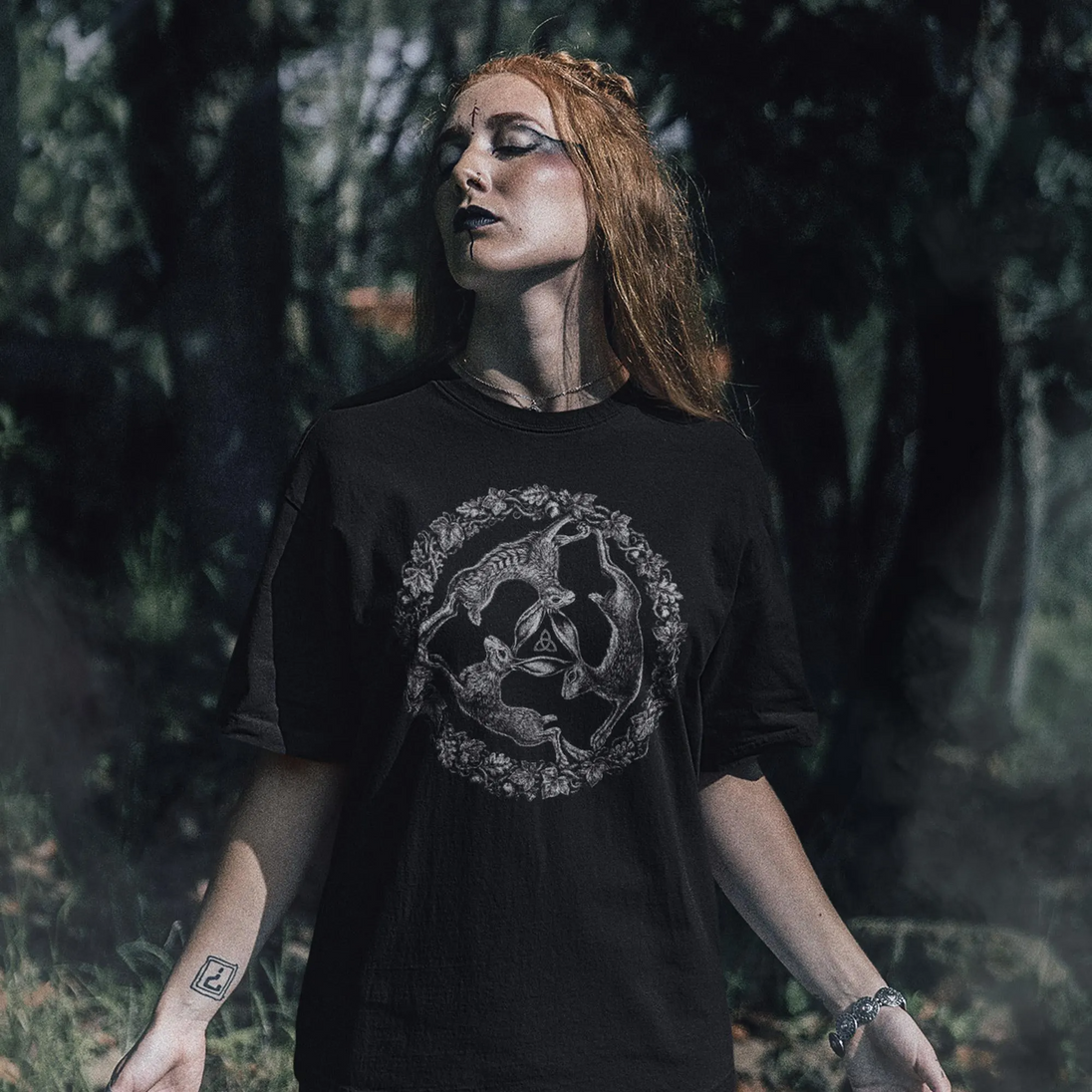 Woman in forest setting wearing black Three Hares T-Shirt