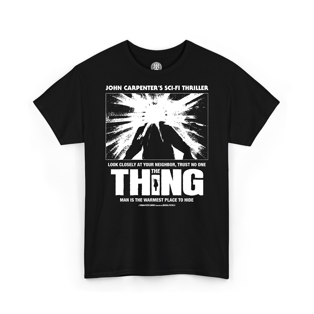 A black short-sleeve crewneck t-shirt featuring a white graphic print of the iconic 'The Thing' sci-fi thriller poster on the front, with text referencing the film.