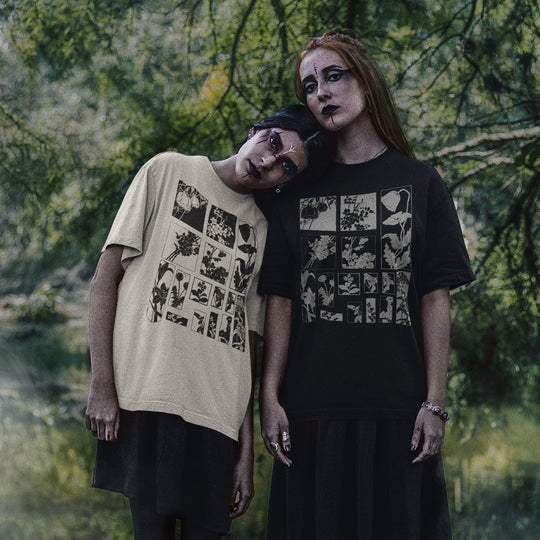 Two models posing outdoors in front of a blurred forest background, wearing graphic t-shirts. The model on the left wears a beige t-shirt with a black graphic print, and the model on the right wears a black t-shirt with a white graphic print.