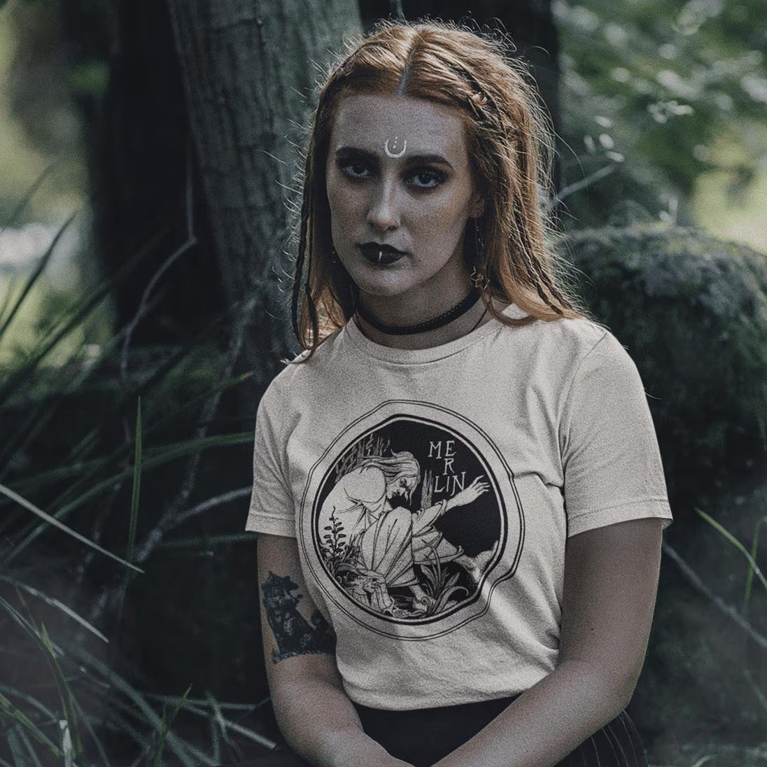Woman in forest setting wearing beige Merlin T-Shirt
