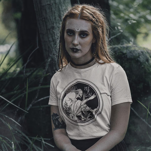 Woman in forest setting wearing beige Merlin T-Shirt
