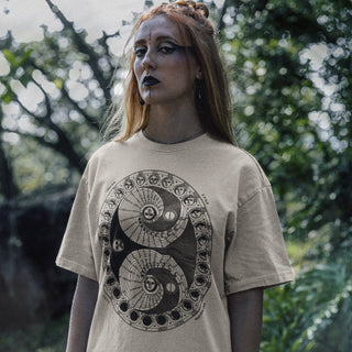 Person wearing a beige Moon Phases T-Shirt with a black symbol design outdoors