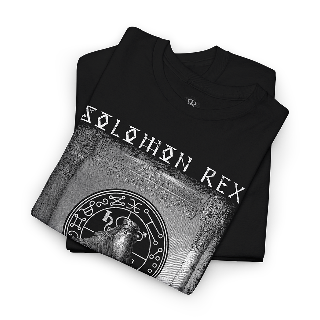 A folded black t-shirt with a grayscale graphic print featuring the text 'SOLOMON REX' and a circular mystical emblem, displayed on a clean white background.