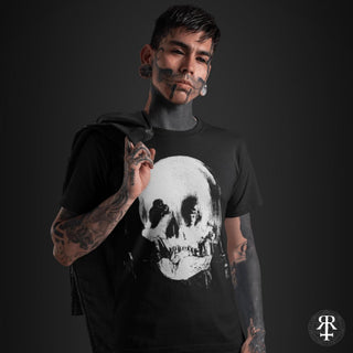 Person wearing a black t-shirt with a skull design on a dark background