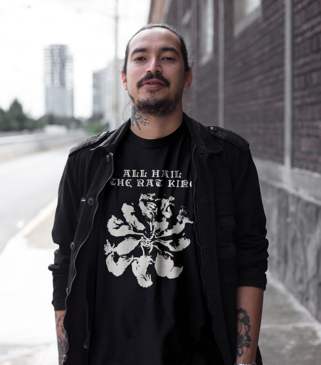 Alternative man wearing black t-shirt with a graphic saying ALL HAIL THE RAT KING
