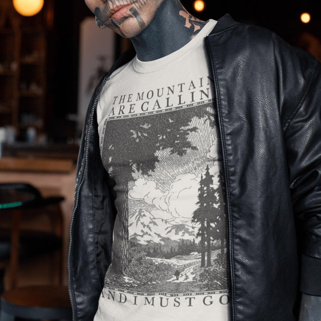 Tattooed man wearing beige The Mountains Are Calling And I Must Go T-Shirt