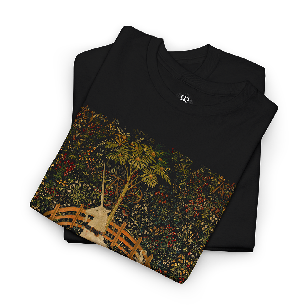 Black t-shirt featuring a central vintage illustration of a unicorn in a garden, surrounded by floral and fantastical elements reminiscent of medieval tapestries.